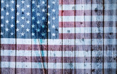 Eski bir tahta duvarda yıpranmış ve yıpranmış Amerika Birleşik Devletleri bayrağı