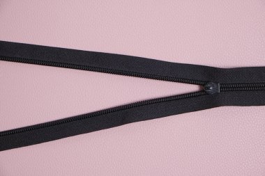 Fermuar pembe arka planda siyahtır.