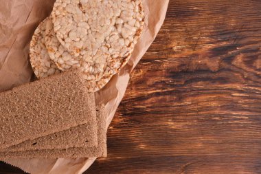 Yiyecek kağıdında, tahta zeminde buğday ekmeği. Kilo vermek için sağlıklı yiyecek.