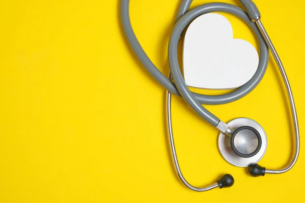Bílé Srdce Stetoskop Žlutém Pozadí Srdeční Onemocnění Lékařské Vyšetření — Stock fotografie