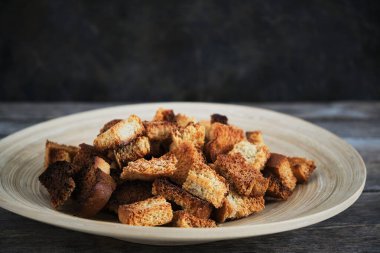 Ahşap tabak ve kızarmış ekmek kırıntıları koyu arka plan. Kırsal alan ve yiyecek