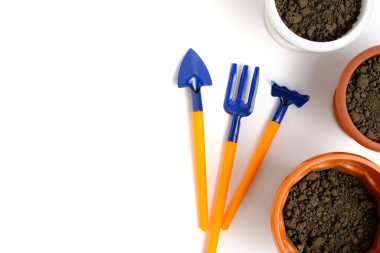 Topraklı saksılar ve dekoratif bahçe araçlarını beyaz arkaplana yerleştir