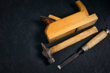 Koyu arkaplanda marangozlar, çekiç, keski ve uçak seti