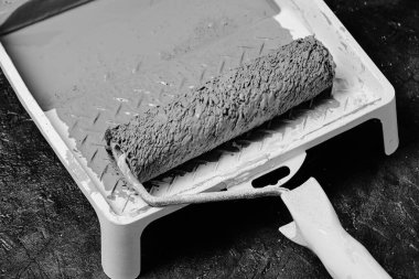 Beton zeminde gri boyalı tekerlekli sandalye tepsisi. Siyah beyaz fotoğraf.