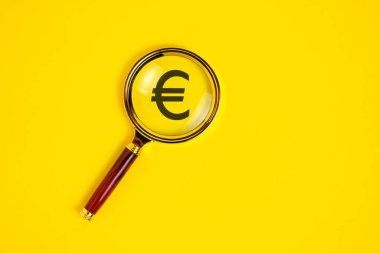 Sarı arkaplanda, büyüteç altında Euro sembolü