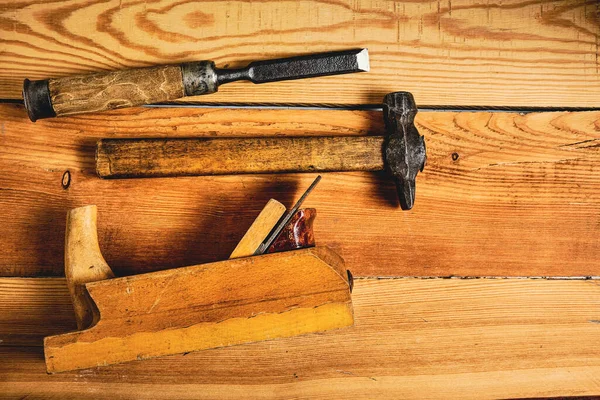 Set of tools for carpenters, hammer, chisel and plane on wooden background