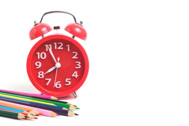 Red alarm clock and set colored pencils white background.Time to prepare for school