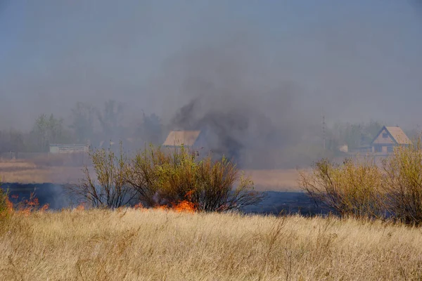 在背景房屋的基础上焚烧黄色的干草 闷热干旱 火灾危险天气 — 图库照片