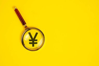 Yuan sembolü büyüteç altında, sarı arkaplanda