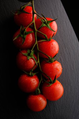 Kağıt üzerinde ve siyah arkaplanda vişne domatesleri