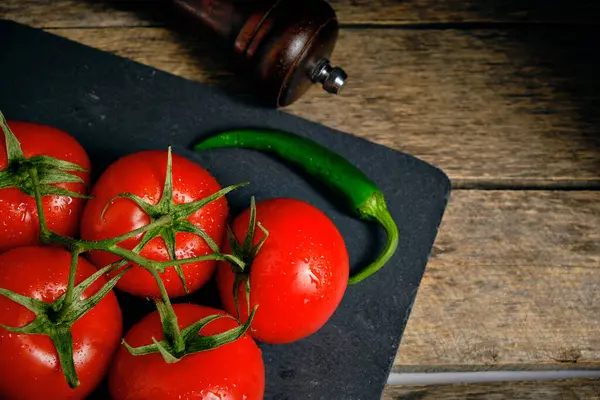 Röda Tomater Och Grön Varm Peppar Skiffer Bakgrunden Två Peppar — Stockfoto