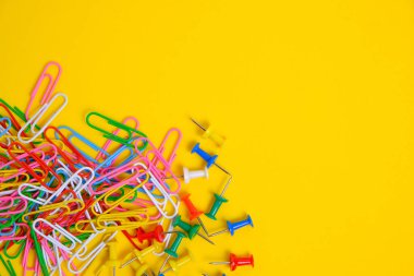 Renkli ataçlar ve düğmeler sarı arkaplan