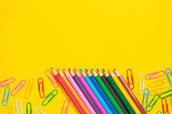 Kolorowe Ołówki Spinki Papieru Żółte Tło — Zdjęcie stockowe