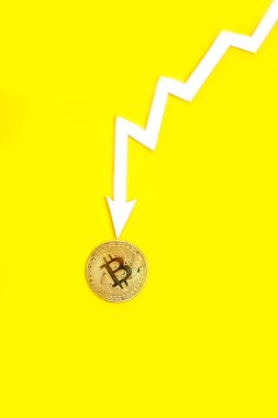 Arrow of graph indicates fall and collapse value bitcoin cryptocurrency yellow background