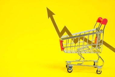 Grocery cart and graph arrow pointing up and rising prices for goods, on yellow background