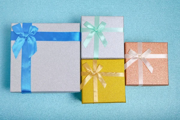 Holiday gifts in gift boxes blue shiny background