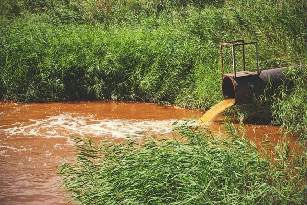 Turuncu suyu oluşturan endüstriyel atıklar borudan nehre akıyor.
