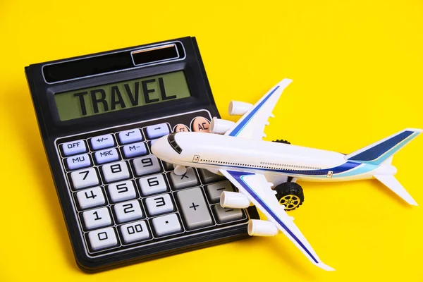 Calculator with inscription travel and white plane yellow background.Concept preparing budget for vacation