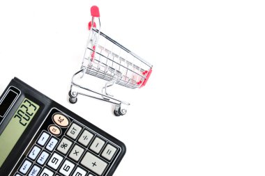 Calculator and shopping cart on white background.Concept of shopping and grocery shopping