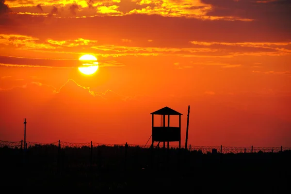 Забор Колючей Проволокой Старым Фоном Сторожевой Башни Яркое Солнце Алый — стоковое фото