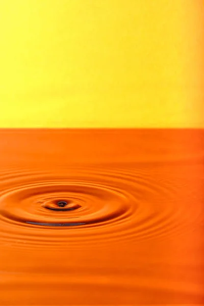 Splash Drop Water Diverging Water Circles Orange Background — Φωτογραφία Αρχείου