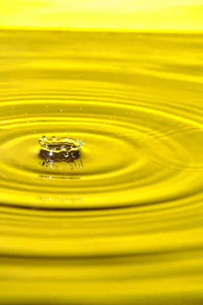 Splash Drop Water Diverging Water Circles Yellow Background — Stock Photo, Image