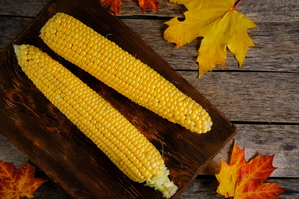 Two Corn Wooden Chopping Board Autumn Maple Leaves Falling Table — Stock Photo, Image