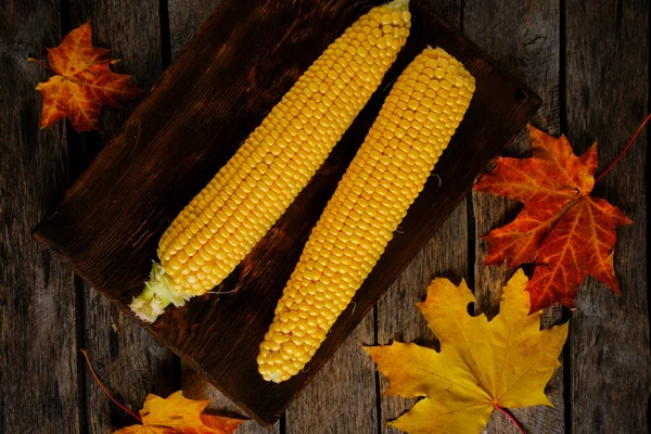 Two Corn Wooden Chopping Board Autumn Maple Leaves Falling Table — Stock Photo, Image