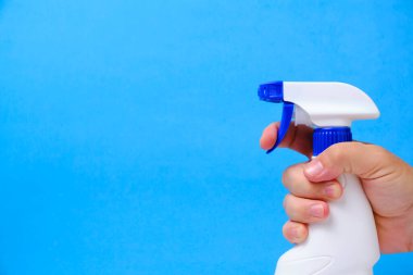 Pencereleri temizlemek ve yıkamak için sprey sıkma, mavi arka planda tesisat.