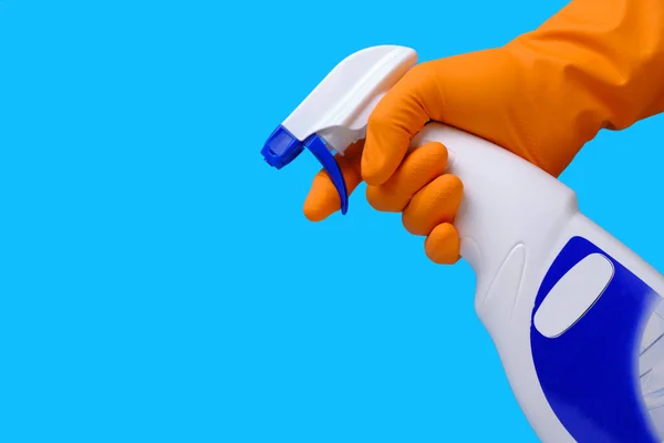 Sprayer for cleaning windows and plumbing in hand with glove on blue background