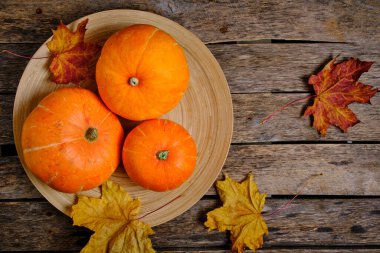 Balkabakları ve düşen sonbahar yaprakları ahşap arka plan