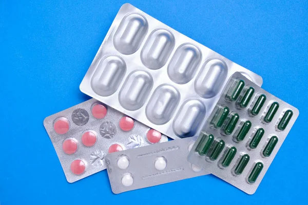 パッケージブルーの背景に丸薬の多く 概念不足と価格医薬品の上昇 — ストック写真