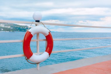 Can simidi denizin arka planında çitlere asılı..