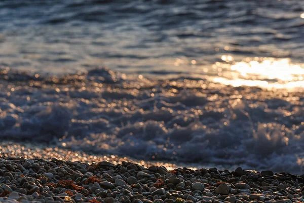 Морська галька на березі моря на світанкових променях — стокове фото