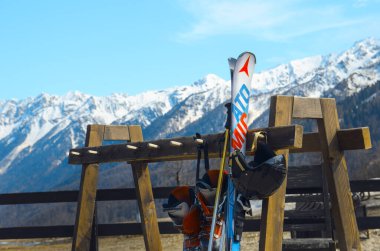 Aşağı istasyon Rosa Khutor, Rusya - 20 Nisan 2016. Alp kayakları, botlar, miğfer, dağların arka planında bir rafta duran sopalar.