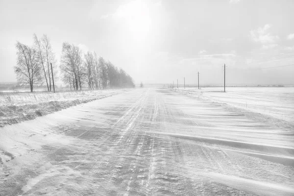 Icy winter road. A blizzard is sweeping the road. — Stok fotoğraf