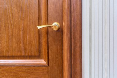 Kapalı ahşap kapının metal sapı ve iç kilidi.