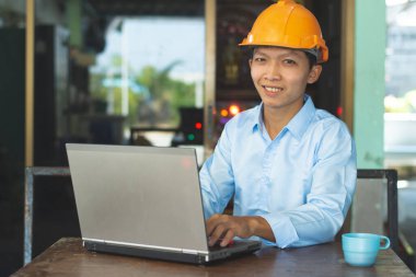 Asyalı erkek mimarlar iş fikirleri ve teknoloji üzerinde çalışmak için dizüstü bilgisayar kullanıyorlar..