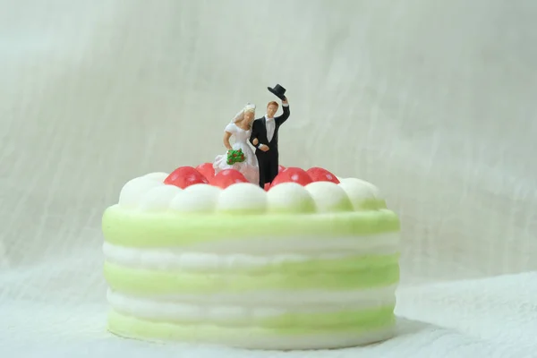 白い背景のケーキの上に立っている花嫁と新郎 画像の写真 — ストック写真