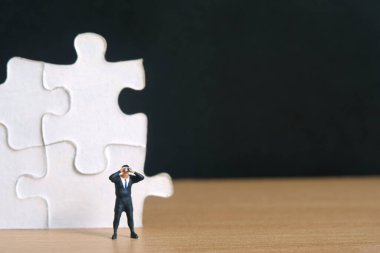 İşadamları yapboz parçalarının önünde tahta masadaki dürbünle duruyorlar. Minyatür minyatür insanlar, oyuncaklar fotoğrafçılık..