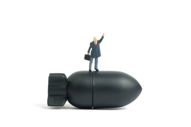 Minyatür insanlar oyuncak fotoğrafçılık. Nükleer füzenin üzerinde duran bir işadamı elini kaldırıyor. Beyaz arka planda izole edilmiş. Resim fotoğrafı.