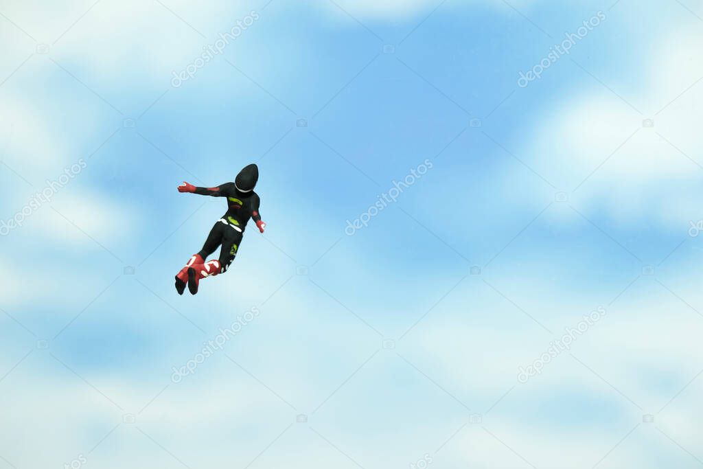 Miniature people toy figure photography. A men doing sky diving jump in cloudy bright day. Image photo