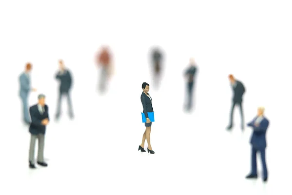 Miniature people toy figure photography. Women empowerment concept. A businesswoman standing in the middle of male people crowd. Isolated on white background. Image photo