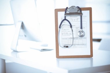 Stetoskop ve ilaç geçmişi olan dosya doktorların çalışma yerinde masanın üstünde. İlaç ve sağlık hizmetleri kavramı