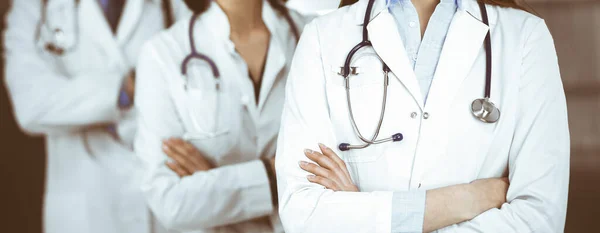 Group of professional doctors is standing as a team with arms crossed in clinic. Medicine concept during Coronavirus pandemic — Stock Photo, Image