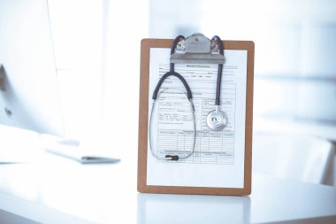 Stetoskop ve ilaç geçmişi olan dosya doktorların çalışma yerinde masanın üstünde. İlaç ve sağlık hizmetleri kavramı