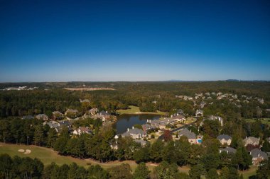 ABD 'nin Georgia kentindeki Atlanta metrosunda golf sahası ve gölü olan banliyödeki bir alt bölümdeki ev kümesinin hava panoramik görüntüsü altın saat içinde insansız hava aracıyla vuruldu..