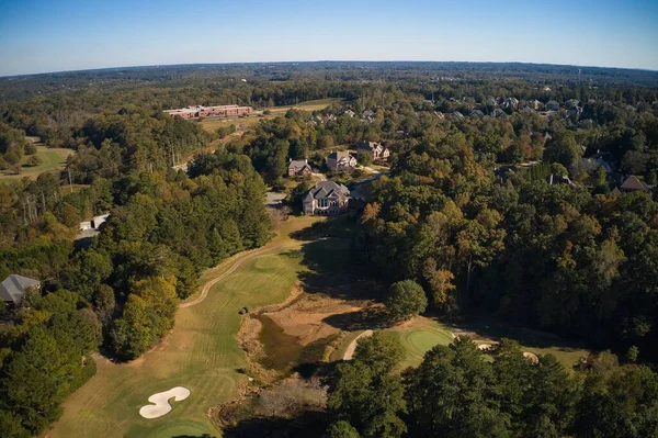 ABD 'nin Georgia kentindeki Atlanta metrosunda golf sahası ve gölü olan banliyödeki bir alt bölümdeki ev kümesinin hava panoramik görüntüsü altın saat içinde insansız hava aracıyla vuruldu..