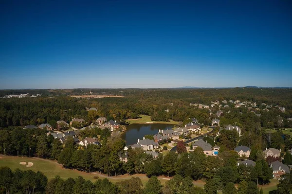 ABD 'nin Georgia kentindeki Atlanta metrosunda golf sahası ve gölü olan banliyödeki bir alt bölümdeki ev kümesinin hava panoramik görüntüsü altın saat içinde insansız hava aracıyla vuruldu..
