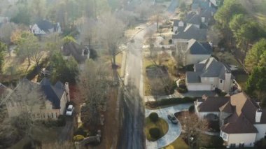 Aralık 2021 'de günbatımında çekilen ev kümeleriyle dolu lüks bir banliyöde 4K hava videosu